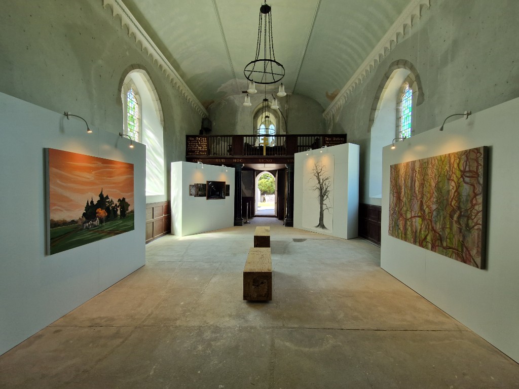 Reverse view of the chapel installation with paintings and central seating.