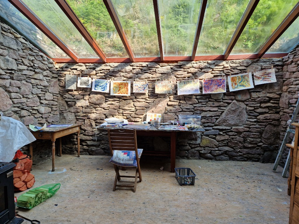 Studio interior under skylights with works-in-progress and materials.